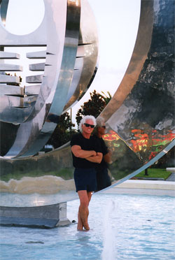 Hal Stowers in front of SUN TIME, his 1999 stainless steel sculpture, FrankCrum, Clearwater, FL Photo by B.J. Stowers